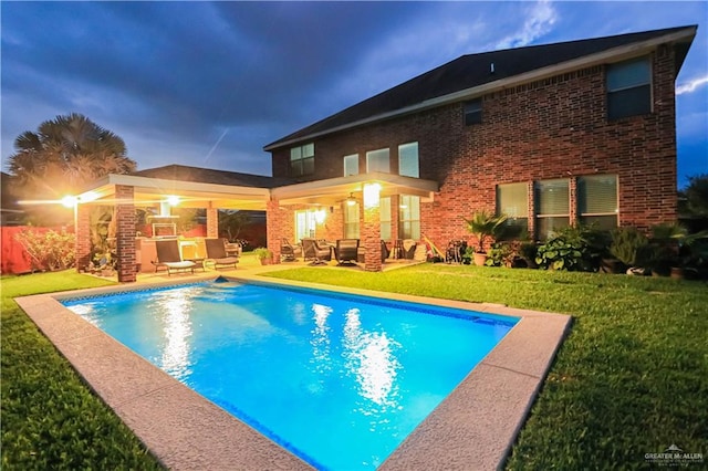 view of swimming pool with a fireplace, a yard, and a patio area