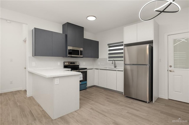 220 W Campeche Ave, Alton, TX 78573 - kitchen with appliances with stainless steel finishes, light countertops, a peninsula, and light wood-style floors