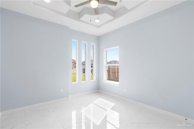 spare room with a tray ceiling and ceiling fan