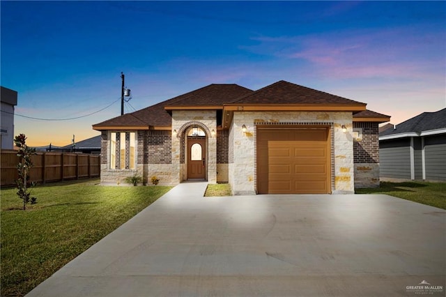 view of front of home featuring a garage and a lawn