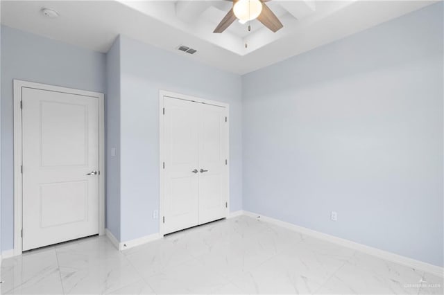 unfurnished bedroom with ceiling fan and a closet