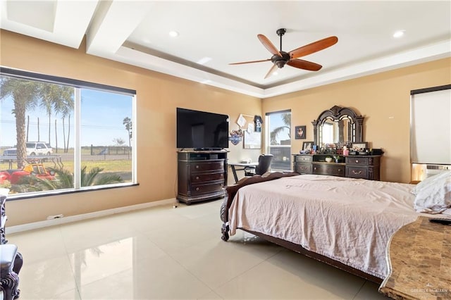 tiled bedroom with a raised ceiling and ceiling fan