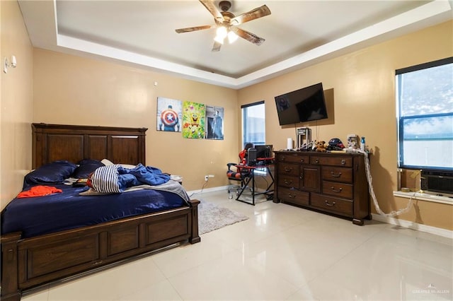 bedroom featuring light tile patterned floors, a raised ceiling, and ceiling fan