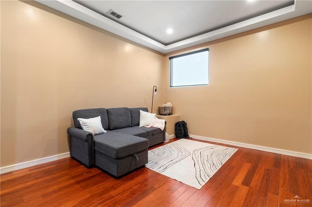 sitting room with a tray ceiling and hardwood / wood-style floors