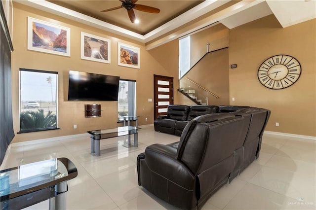 living room featuring a towering ceiling, ceiling fan, and light tile patterned flooring