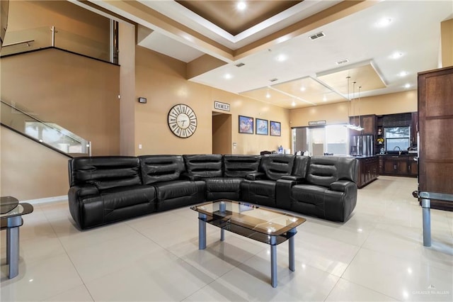 tiled home theater room with a raised ceiling