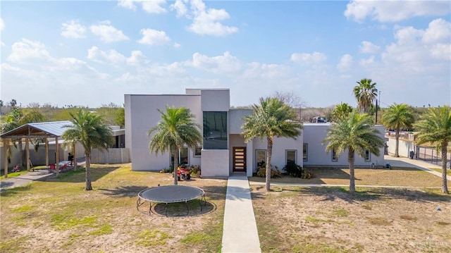 view of front of property featuring a trampoline and a front yard