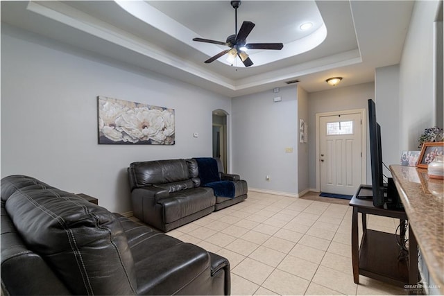 318 Lunar Dr, Donna, TX 78537 - living area featuring a raised ceiling, arched walkways, a ceiling fan, and light tile patterned flooring