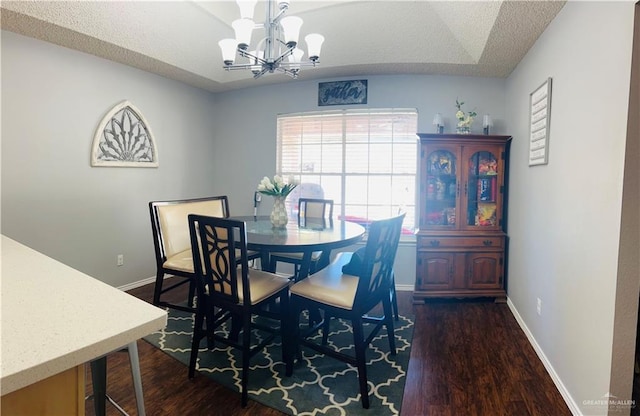 dining area with a textured ceiling, dark hardwood / wood-style flooring, lofted ceiling, and a chandelier