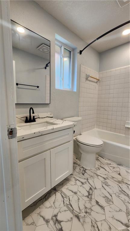 6200 N 31st St, Mcallen, TX 78504 - bathroom featuring vanity, toilet, marble finish floors, bathing tub / shower combination, and a textured ceiling