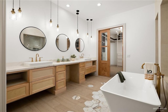 bathroom featuring vanity, hardwood / wood-style floors, and a bathtub