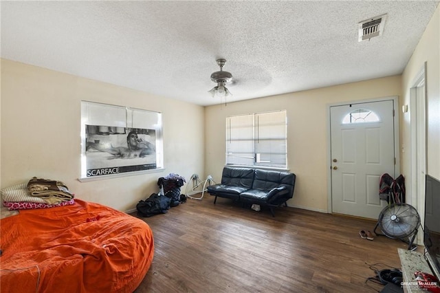 interior space with a textured ceiling, ceiling fan, and hardwood / wood-style flooring