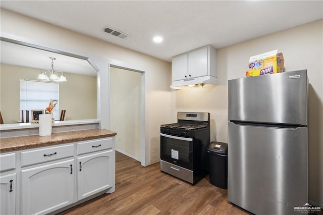 kitchen with a chandelier, decorative light fixtures, stainless steel appliances, hardwood / wood-style floors, and white cabinets