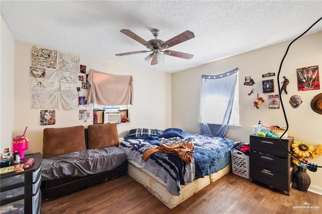 bedroom with cooling unit, hardwood / wood-style floors, a textured ceiling, and ceiling fan