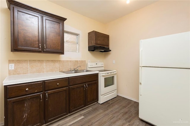 kitchen with dark brown cabinets, white appliances, sink, and dark wood-type flooring