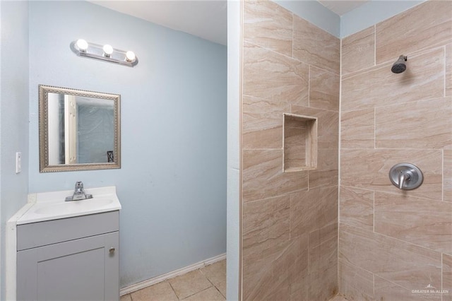 bathroom with tile patterned floors, vanity, and a tile shower