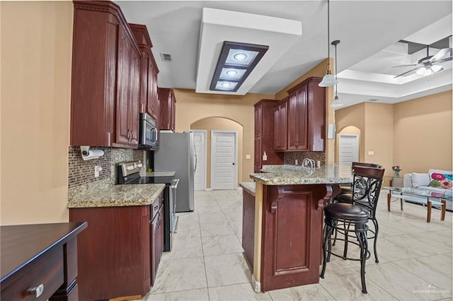 2504 April Ave, Edinburg, TX 78541 - kitchen with arched walkways, stainless steel appliances, a ceiling fan, and light marble finish floors