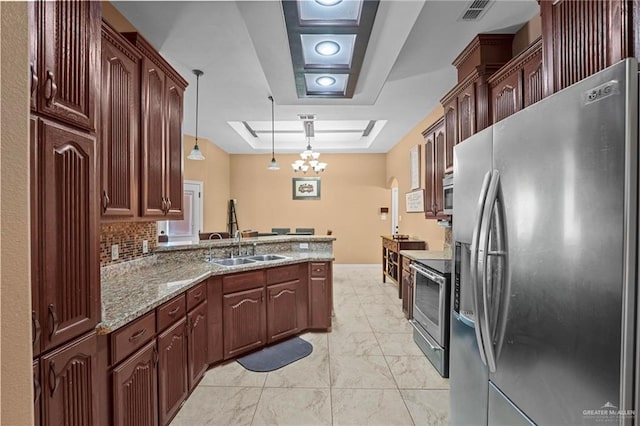 2504 April Ave, Edinburg, TX 78541 - kitchen featuring appliances with stainless steel finishes, a peninsula, a chandelier, decorative light fixtures, and light marble finish flooring