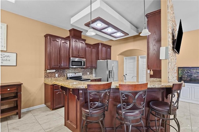 2504 April Ave, Edinburg, TX 78541 - kitchen with stainless steel appliances, light marble finish flooring, tasteful backsplash, a peninsula, and a kitchen bar