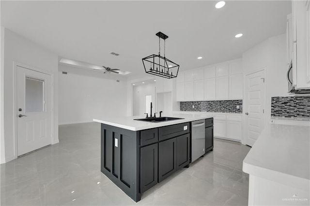 kitchen featuring pendant lighting, a kitchen island with sink, white cabinets, sink, and ceiling fan