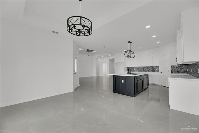 kitchen with ceiling fan, a center island, decorative light fixtures, decorative backsplash, and white cabinets