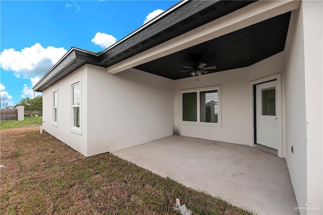 view of property exterior featuring a lawn, ceiling fan, and a patio area