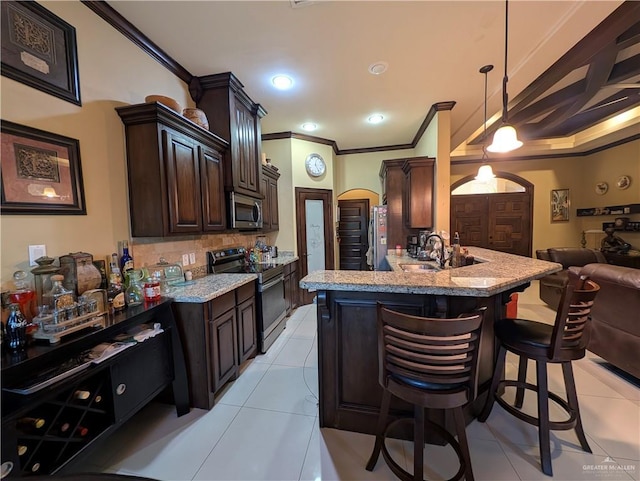 3300 Harding Ave, Alton, TX 78573 - kitchen with stainless steel appliances, ornamental molding, open floor plan, a kitchen bar, and dark brown cabinets