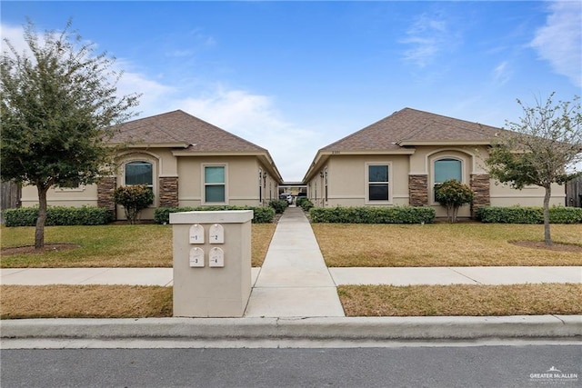 2008 Taft St, Weslaco, TX 78599 - view of front of house featuring stucco siding, stone siding, and a front yard