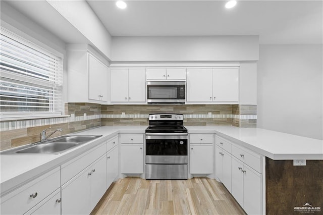 2008 Taft St, Weslaco, TX 78599 - kitchen with appliances with stainless steel finishes, a sink, a peninsula, recessed lighting, and white cabinetry