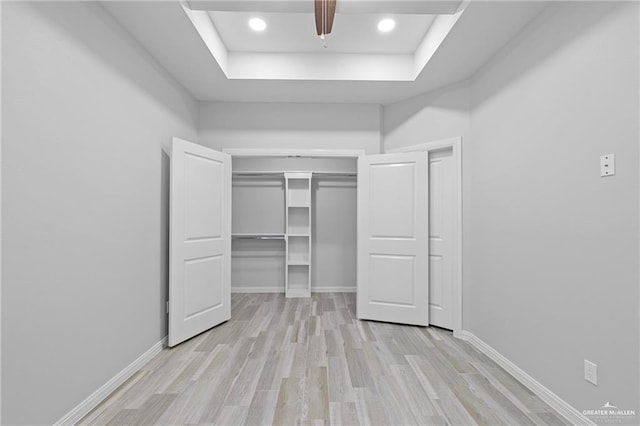 2008 Taft St, Weslaco, TX 78599 - unfurnished bedroom with a raised ceiling, light wood-style floors, a closet, baseboards, and recessed lighting