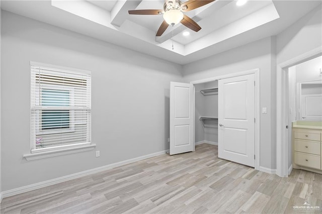 2008 Taft St, Weslaco, TX 78599 - unfurnished bedroom featuring a raised ceiling, light wood-style floors, baseboards, a closet, and a ceiling fan