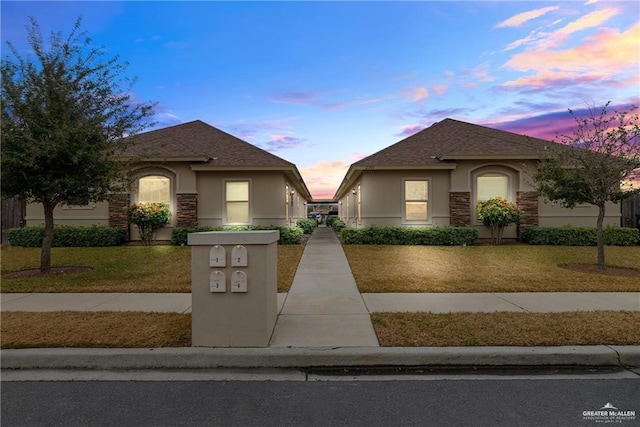 2008 Taft St, Weslaco, TX 78599 - view of front facade with stucco siding, a yard, and stone siding