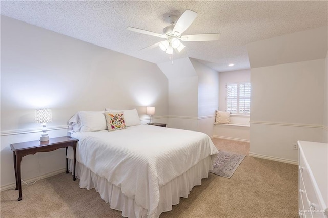 bedroom featuring lofted ceiling, ceiling fan, light carpet, and a textured ceiling