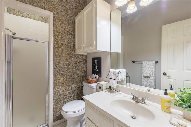 bathroom with toilet, vanity, and walk in shower