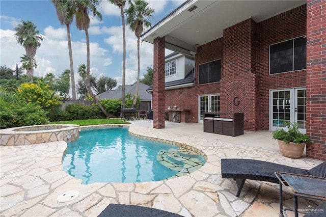 view of pool with a patio area, an in ground hot tub, and french doors