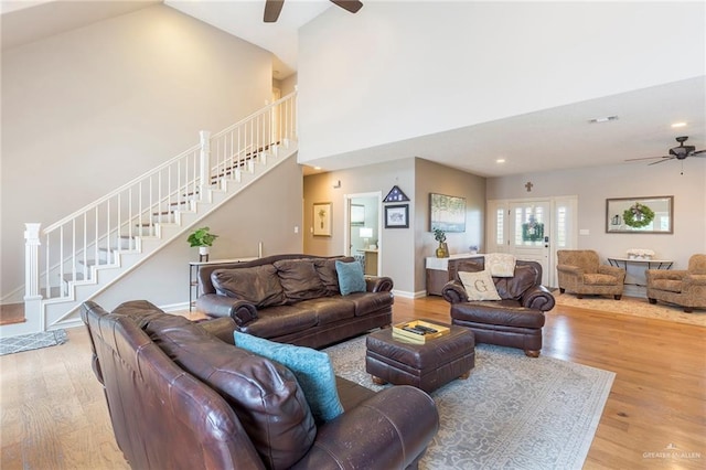 living room featuring ceiling fan, high vaulted ceiling, and light wood-type flooring