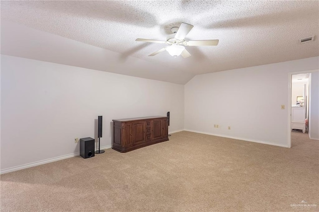 additional living space with lofted ceiling, light colored carpet, and a textured ceiling