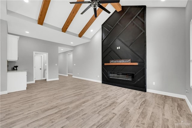 unfurnished living room with beamed ceiling, ceiling fan, high vaulted ceiling, and light hardwood / wood-style floors