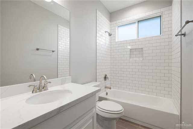 full bathroom featuring vanity, toilet, and tiled shower / bath