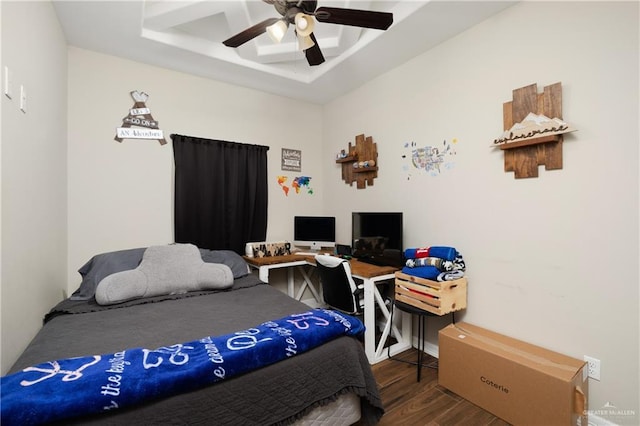 bedroom featuring hardwood / wood-style flooring, ceiling fan, and a raised ceiling