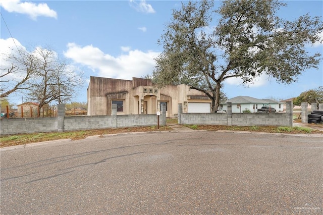 adobe home featuring a fenced front yard and stucco siding