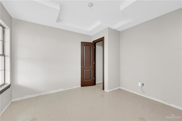 tiled empty room featuring baseboards