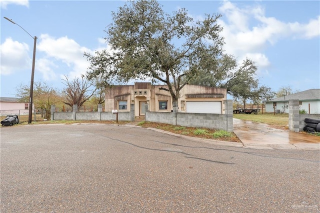 view of front of property with an attached garage and fence