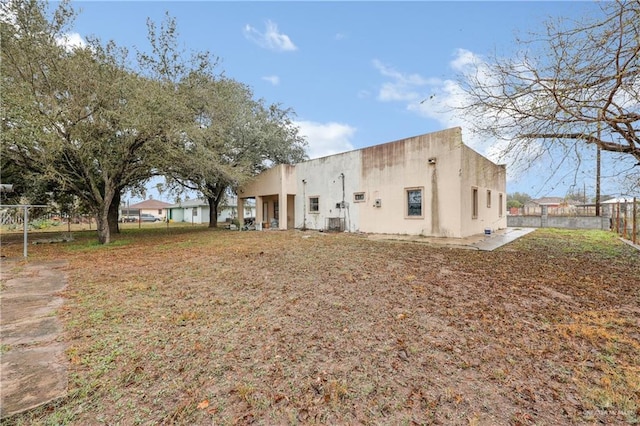 back of property with fence and stucco siding