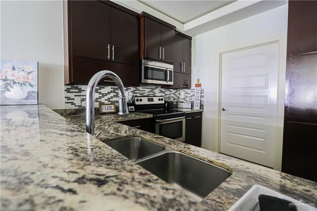 1413 E Keeton Ave Unit 19, Mcallen, TX 78503 - kitchen with dark brown cabinets, appliances with stainless steel finishes, light stone countertops, and tasteful backsplash