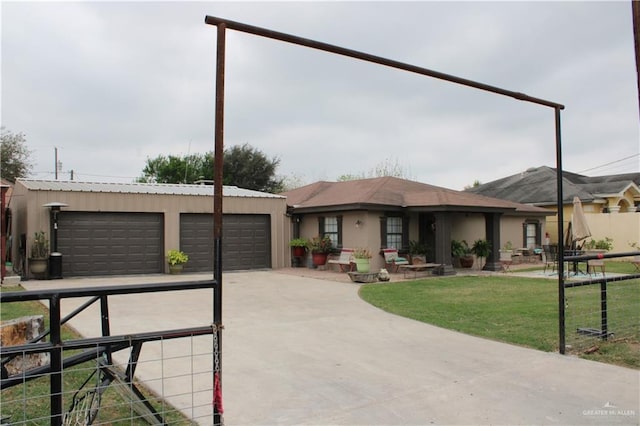 view of front facade featuring an outbuilding, stucco siding, an attached garage, a front yard, and fence