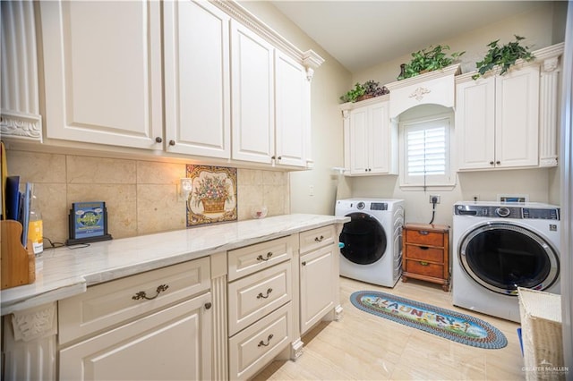 washroom with washing machine and dryer and cabinet space