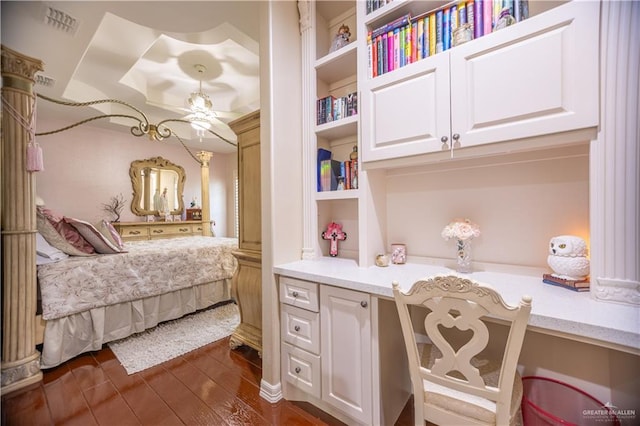 bedroom featuring built in desk and dark wood-style flooring