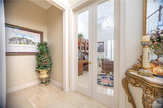 doorway with french doors, a chandelier, and baseboards