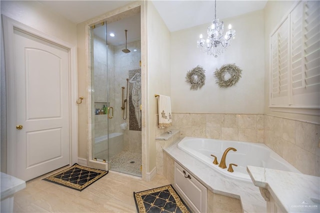 full bathroom with a garden tub, a shower stall, and an inviting chandelier